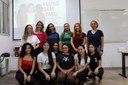 Para cego ver: Foto mostra diversas mulheres agrupadas em dois níveis. Elas integra o projeto. No grupo em pé, estão as servidoras, e nas mulheres abaixadas, as estudantes